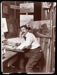 Porträt von Ernest Gross, Bühnenbildner, sitzend in seinem Studio an seinem Zeichentisch, 1908-9